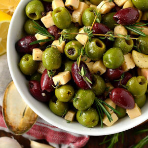 herb and garlic marinated olives and cheese in a serving bowl