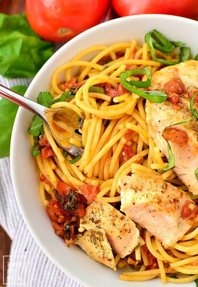 fork twirling pasta with chicken and bruschetta