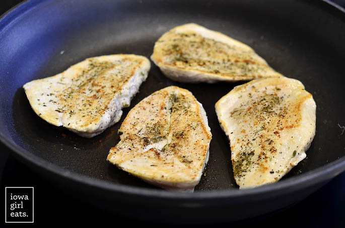 Skillet of chicken cutlets cooking.