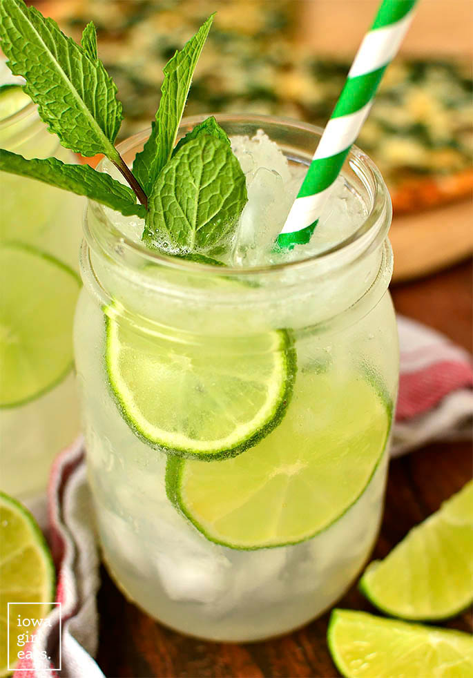 sparkling mint limeade in a glass with lime slices and a straw