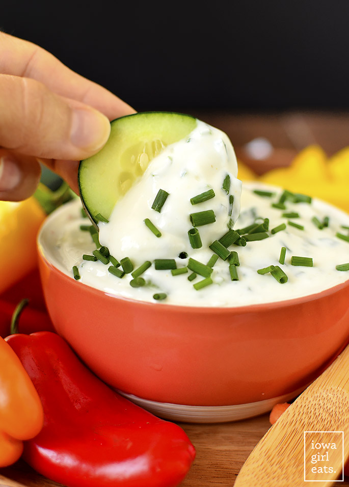 Slice of cucumber dipping into Sour Cream and Chive Dip 