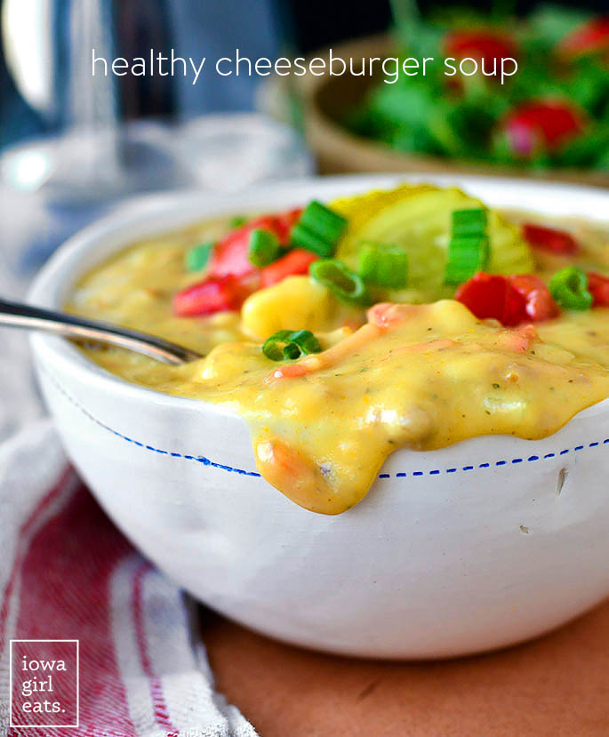 healthy cheeseburger soup overflowing over a soup bowl