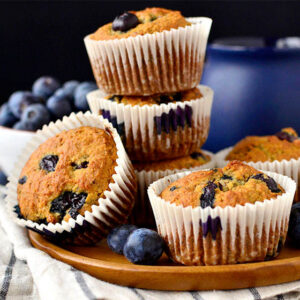 almond flour blueberry muffins on a plate with fresh blueberries