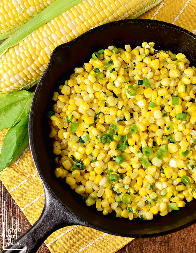 sauteed sweet corn with basil and garlic butter in a skillet