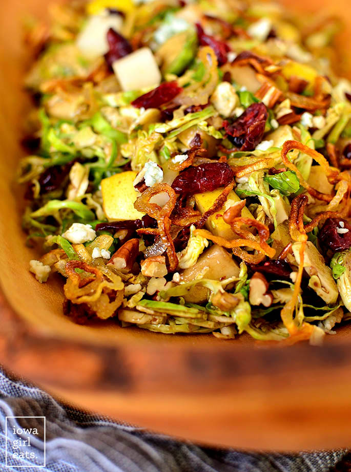 Close up photo of Shredded Brussels Sprouts Salad in a wooden serving bowl