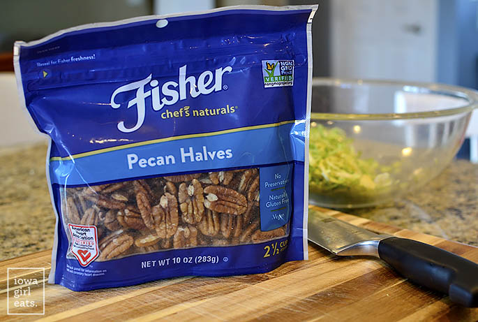 bag of fisher nuts pecan halves on a cutting board with a knife