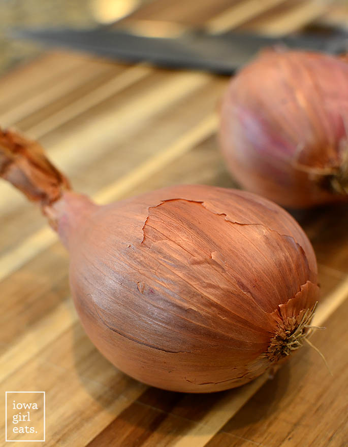 jumbo shallots on a cutting board with a knife
