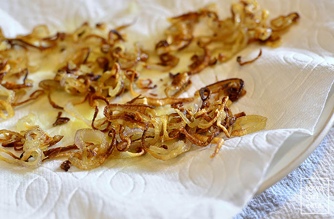 pan fried shallots cooling on a paper towel