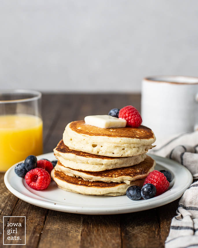 a stack of gluten free pancakes with butter and berries
