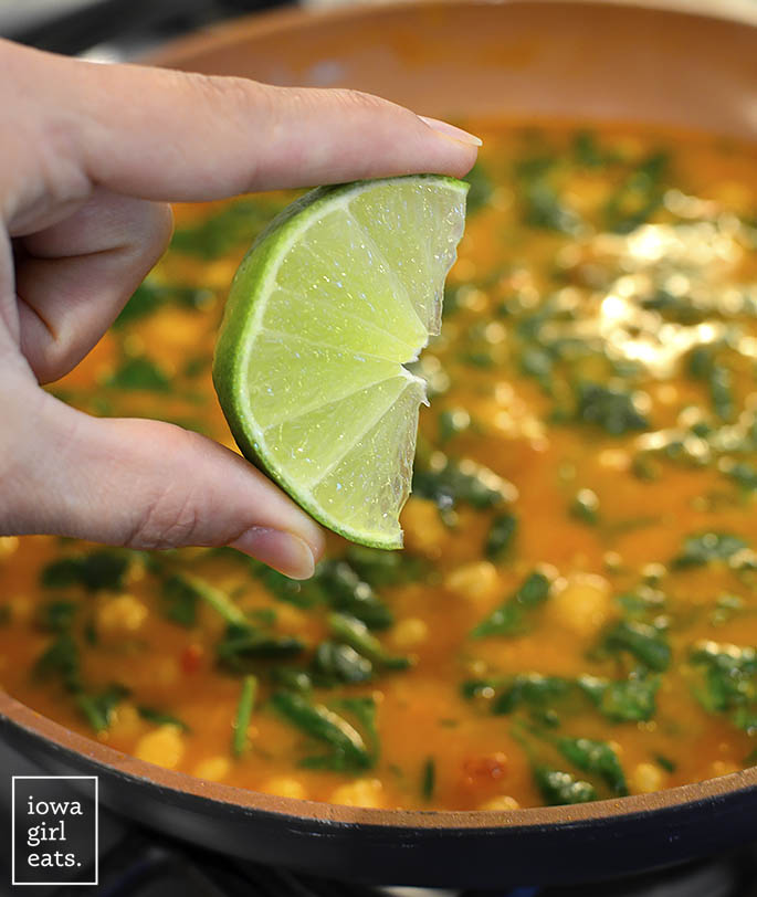 lime being squeezed into coconut chickpea curry