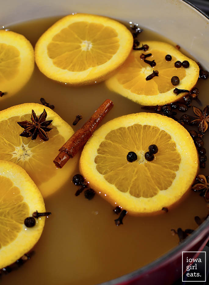 orange, cloves, and cinnamon floating in mulled cider
