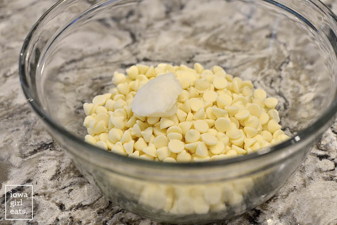 a bowl of white chocolate chips and coconut oil on the counter