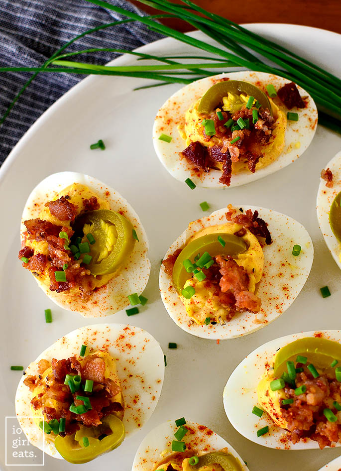 overhead photo of deviled eggs with jalapenos on a platter
