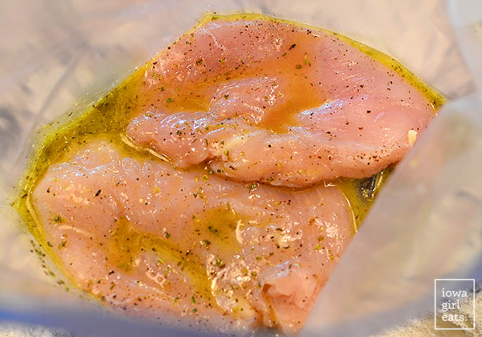 chicken breasts marinating in greek dressing a ziplock bag