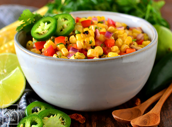 serving bowl of grilled sweet corn salad with spoons