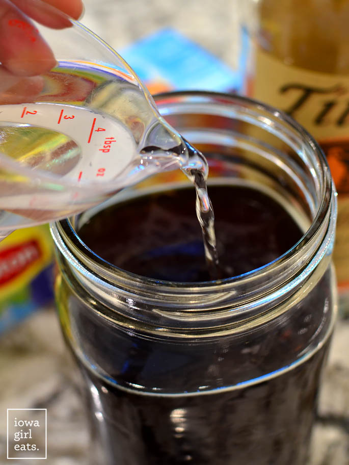 simple syrup being poured into a mason jar