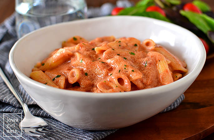 bowl of pink sauce pasta with chopped parsley sprinkled on top