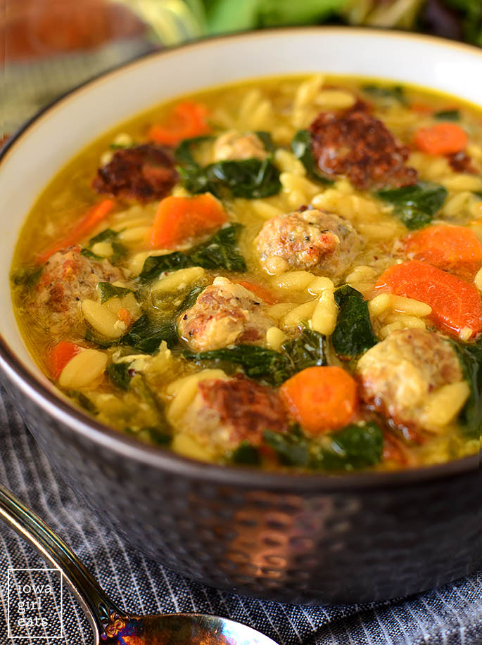 Hearty Italian wedding soup in a bowl with a spoon nearby