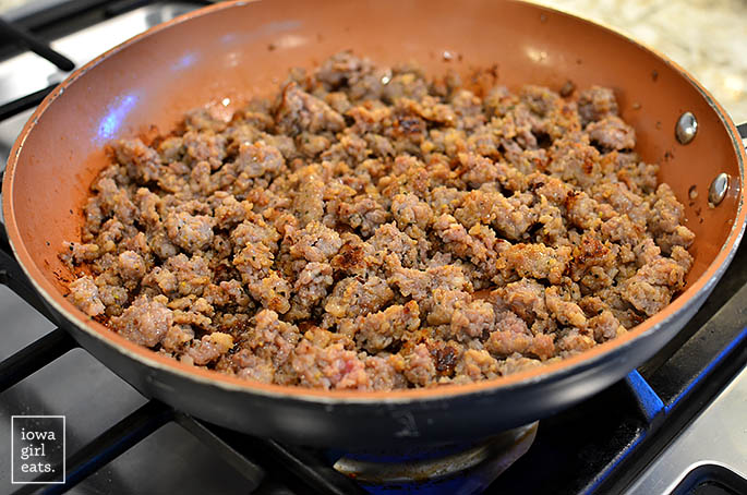 italian sausage browning in a skillet on the stove