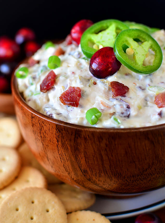 wooden serving bowl with cranberry jalapeno dip inside