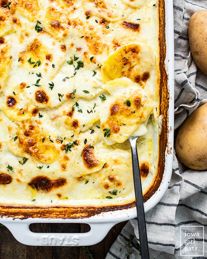 spoon in a dish of gluten free scalloped potatoes
