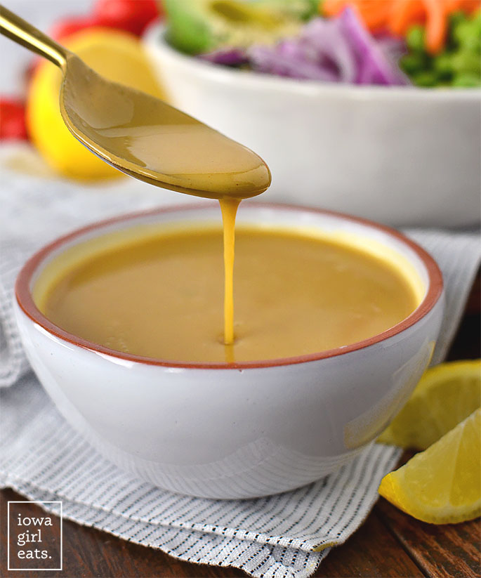 spoon drizzling homemade oil free honey mustard salad dressing