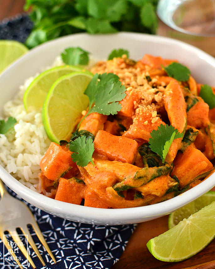 thai sweet potato curry in a bowl with lime wedges and rice