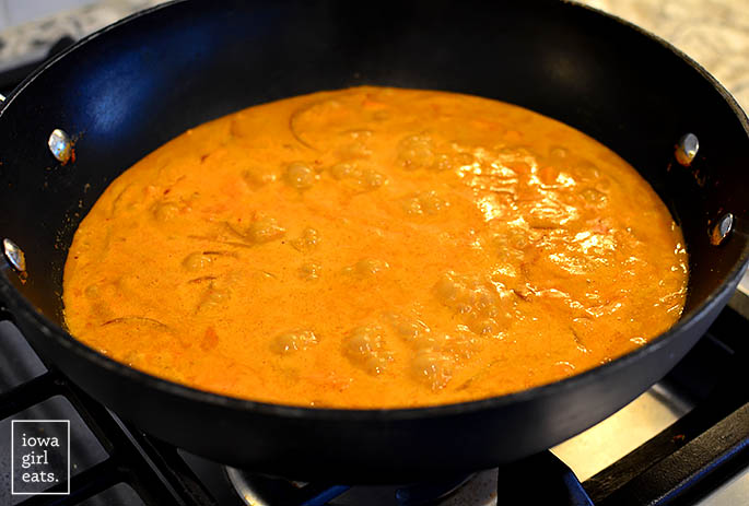 bubbling peanut red thai coconut curry in a wok
