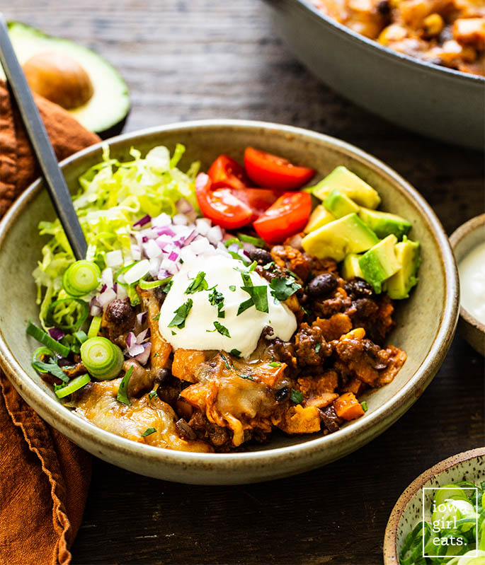Bowl of skillet beef enchiladas with toppings