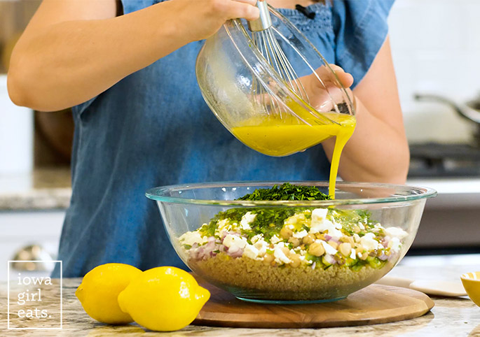 drizzling a lemon dressing into a salad