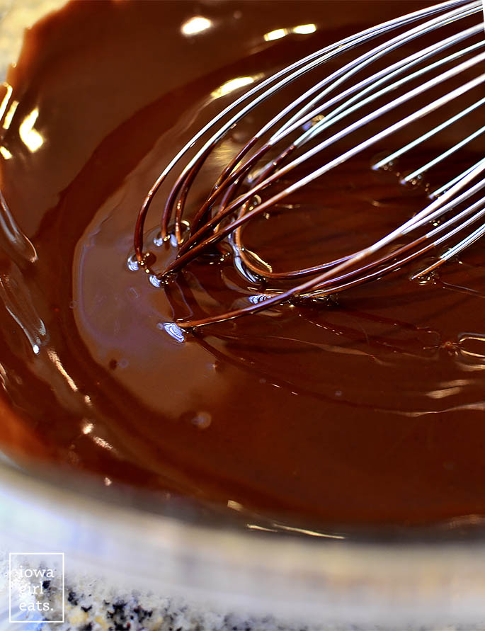 Melted butter and chocolate in bowl with whisk