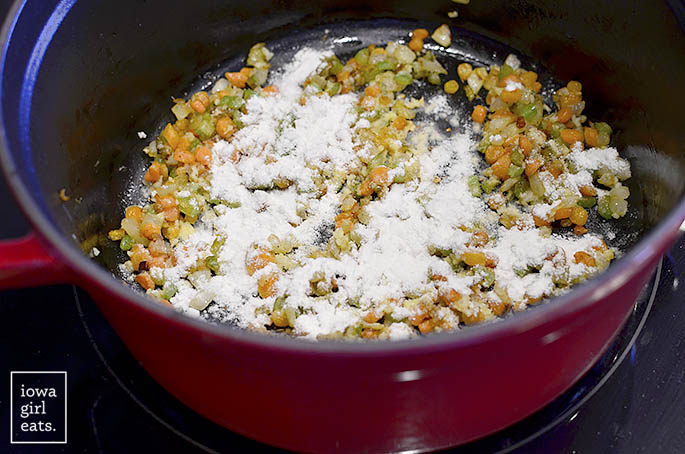 Flour added to sauteed vegetables in pot