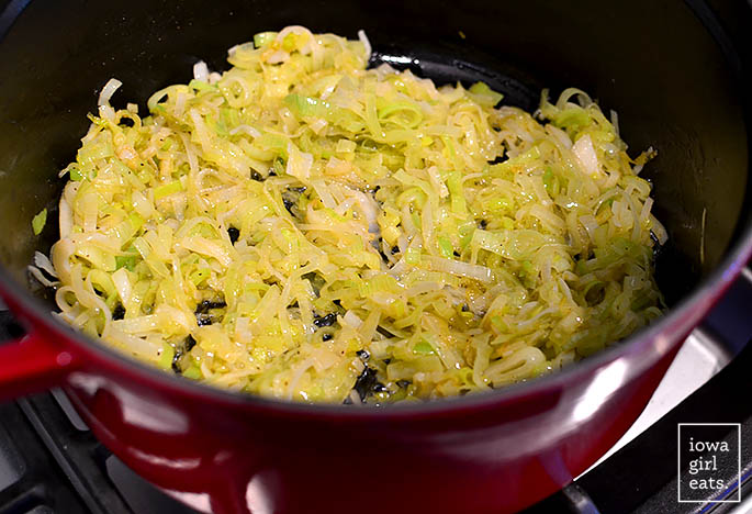 sliced leeks sauting in butter in a dutch oven