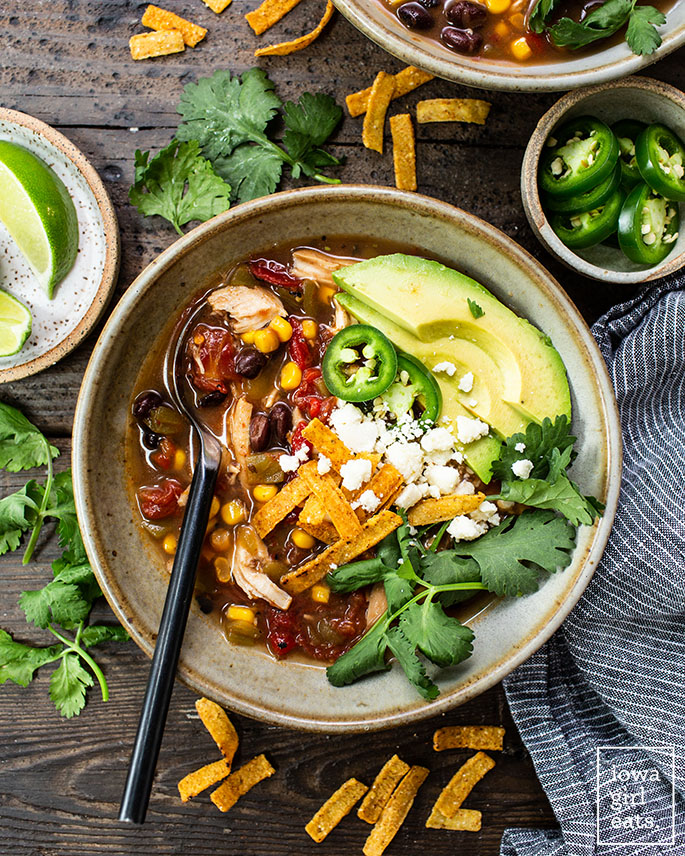 bowl of crock pot chicken tortilla soup with toppings