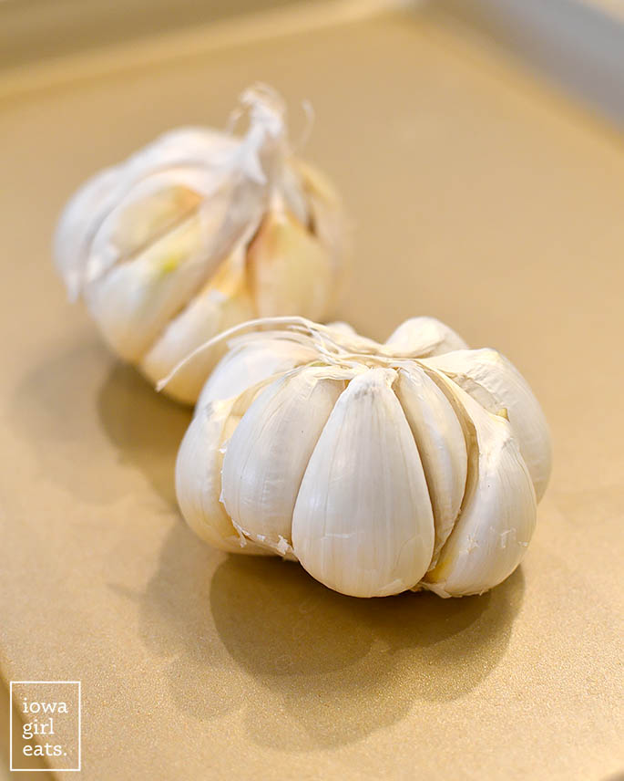 heads of garlic on a baking sheet