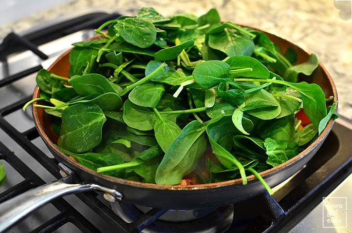 baby spinach sauting in a skillet