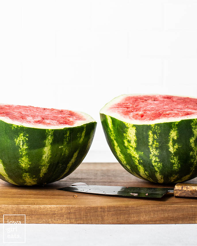 a watermelon sliced in half on a cutting board