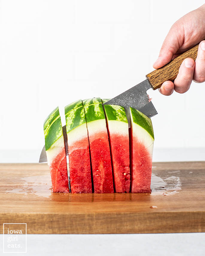 a knife cutting watermelon into sticks
