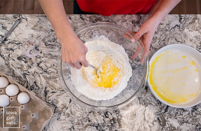 hand incorporating eggs into gluten free flour
