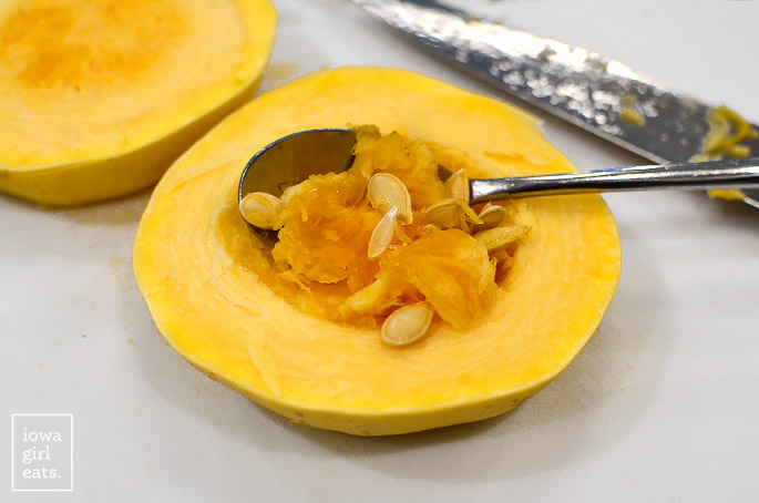spoon removing the seeds from spaghetti squash