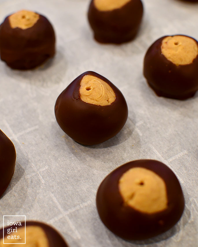 chocolate dipped peanut butter balls on parchment paper