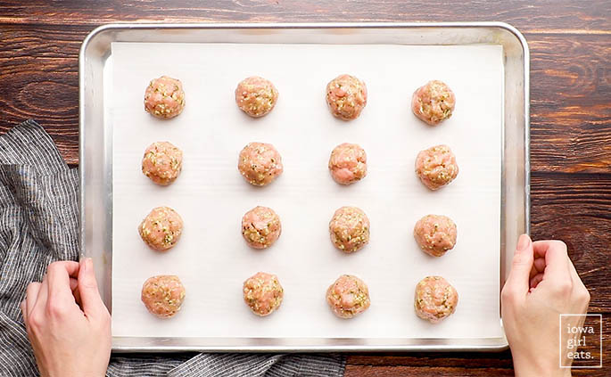 raw chicken meatballs on a baking sheet