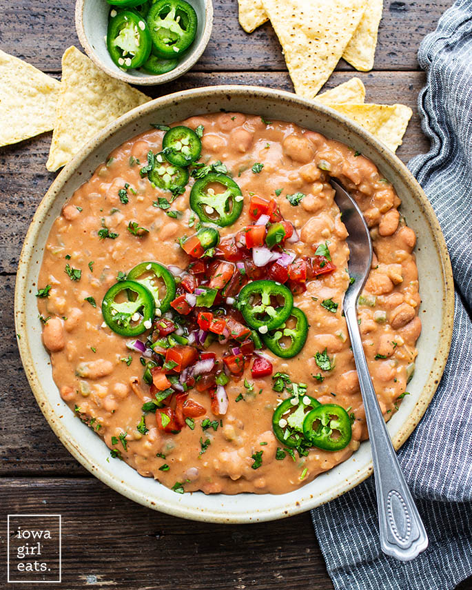 bowl of creamy pinto beans with toppings