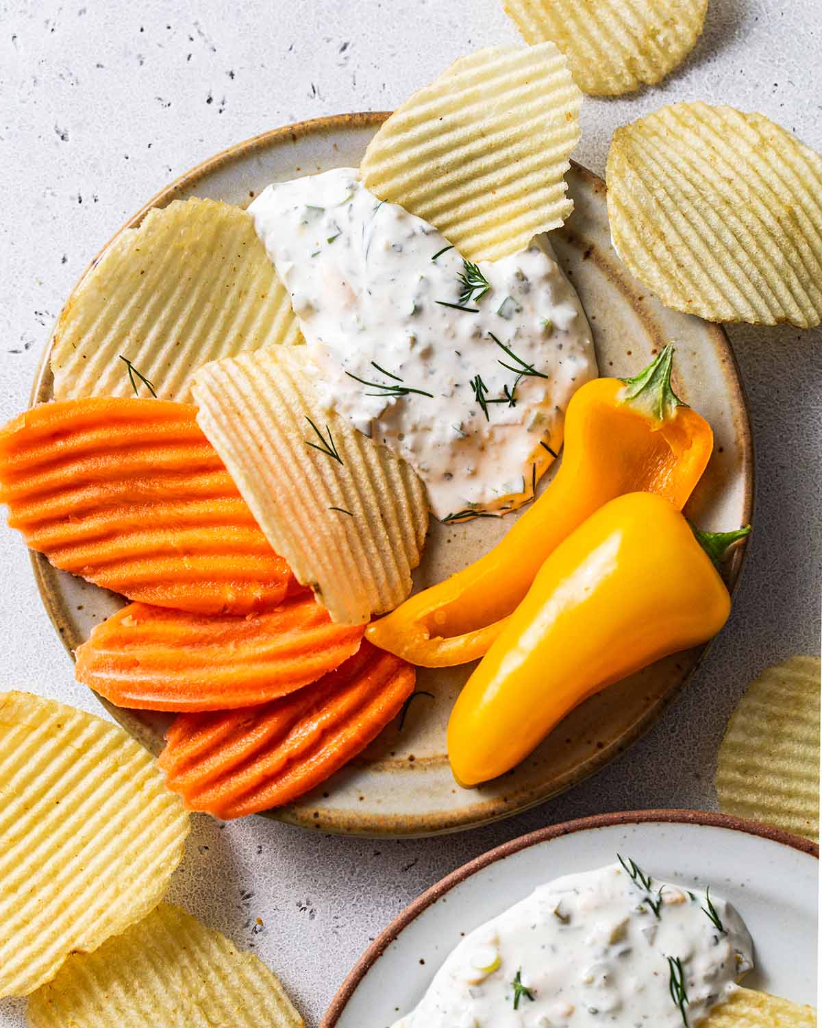 close up photo of creamy pickle dip on a plate with dippers