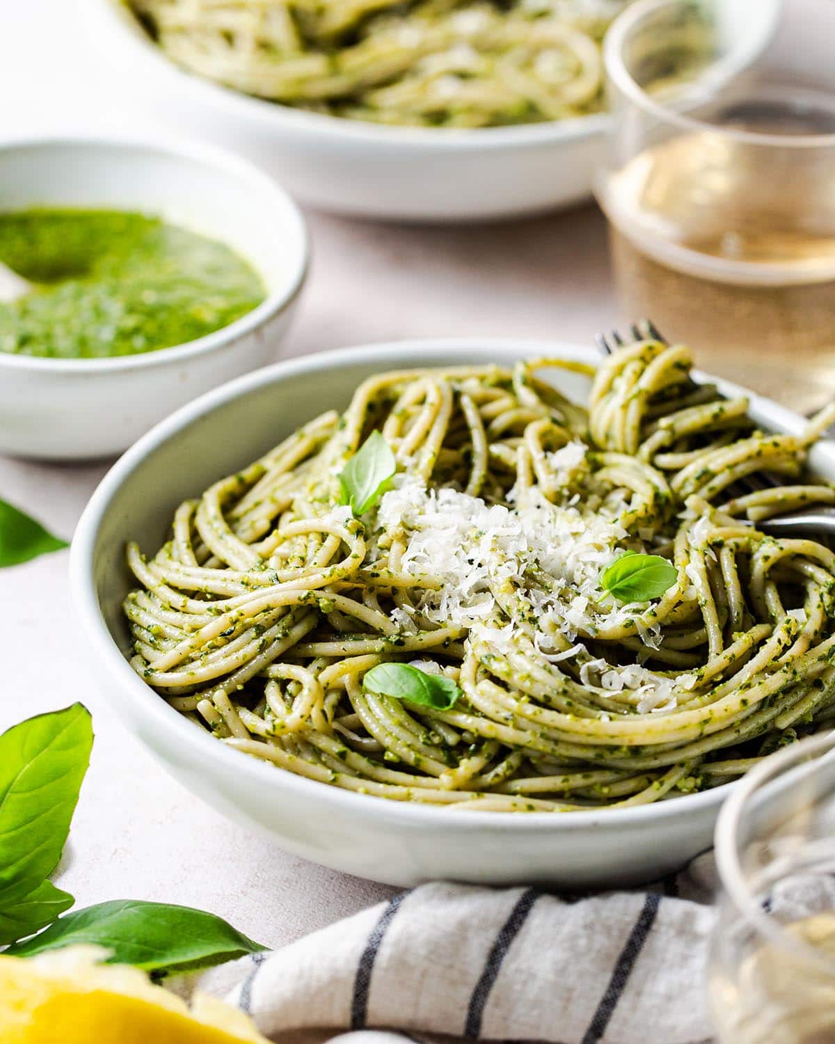 pesto pasta in a bowl with parmesan cheese