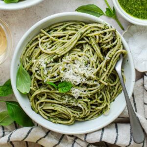 pesto pasta in a bowl with parmesan cheese